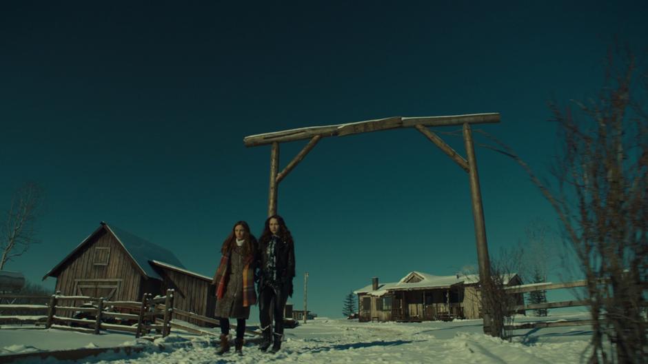 Waverly and Wynonna walk under the Earp sign out of the homestead.