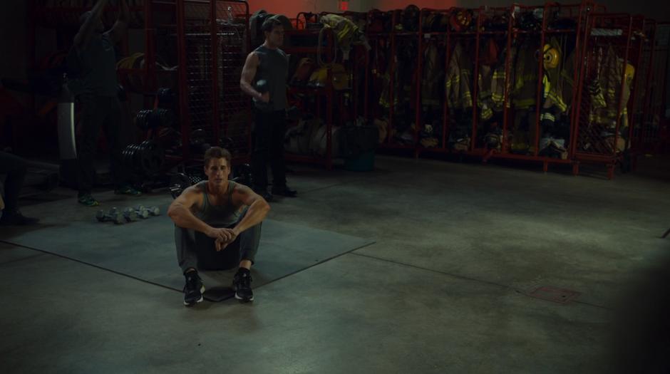 Ewan looks up from where he is sitting in the firehall as Wynonna enters.
