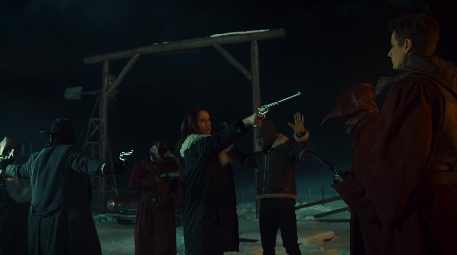 Wynonna holds Peacemaker at Ewan while Doc, Dolls, and the Order are at a standoff.