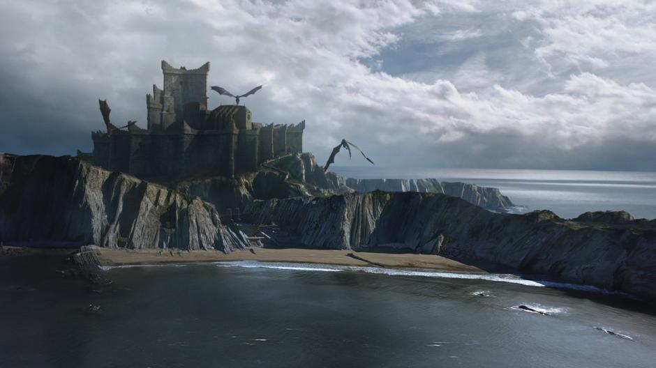 The three dragons fly over the beach toward the castle of Dragonstone.