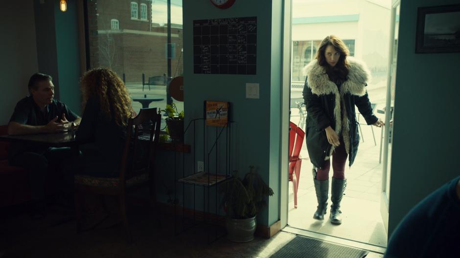 Wynonna enters the cafe in her big coat.