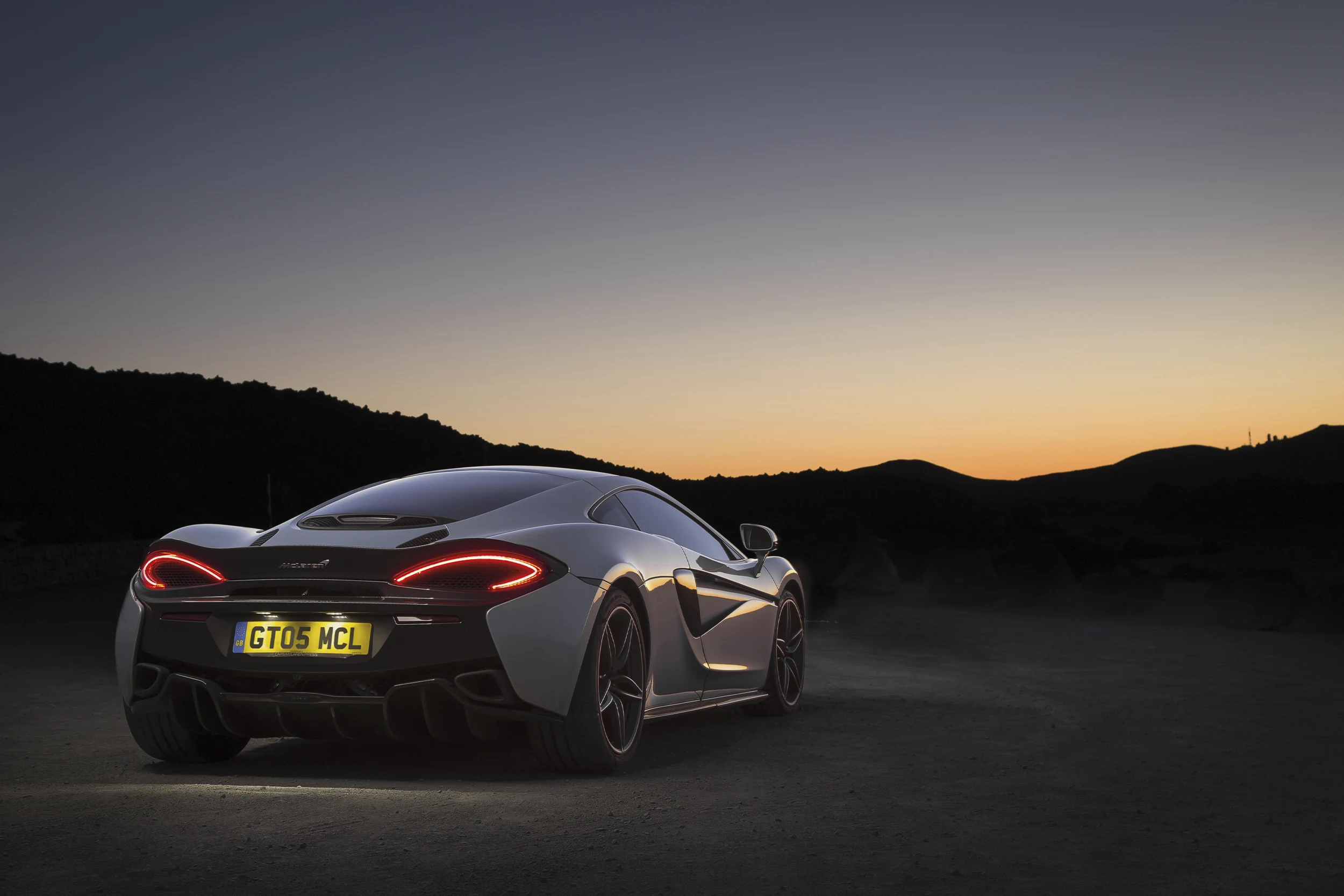 McLaren Boston 570GT Blacj 570GT at sunset, with mountains in background