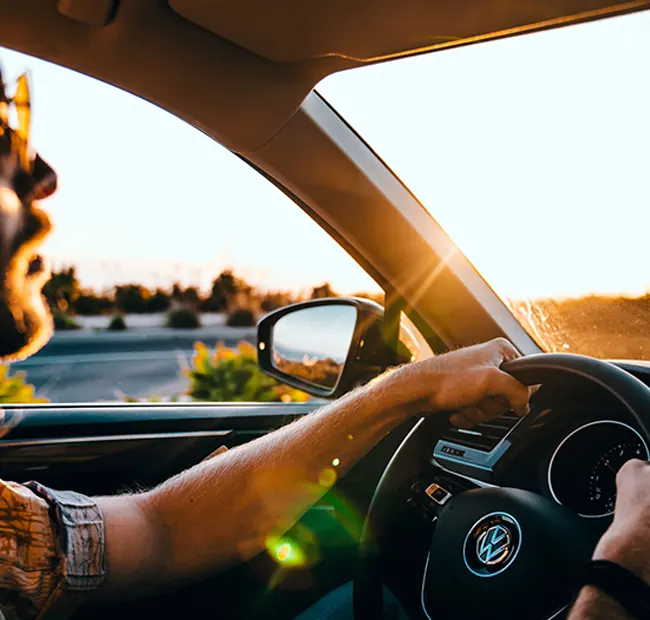 Man driving his car with the window down listening to the radio VW CPO 3-Month SiriusXM