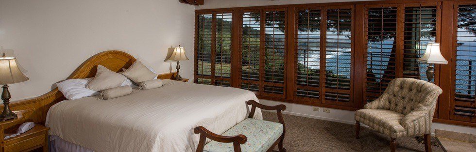 large bed near full wall of windows overlooking ocean