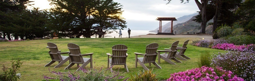 adirondack chairs on grassy area overlooking ocean