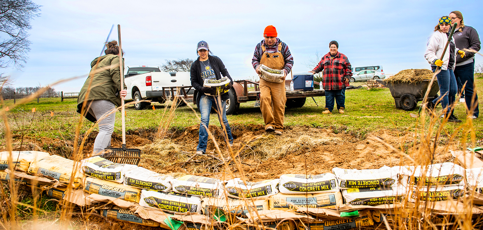 Group building a barrier from concrete bags.