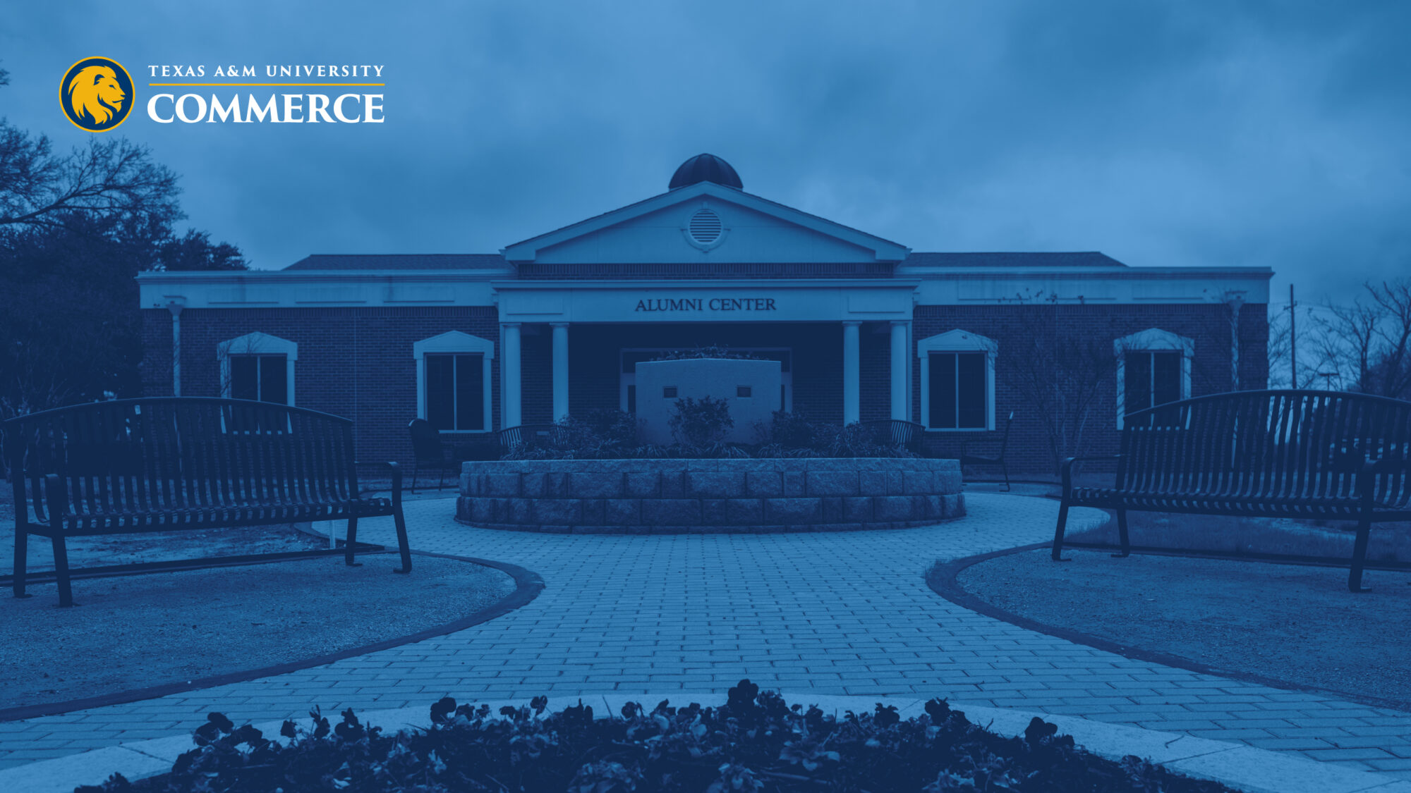 Alumni Center building with blue overlay and the Texas A&M University - Commerce logo on the top left corner.