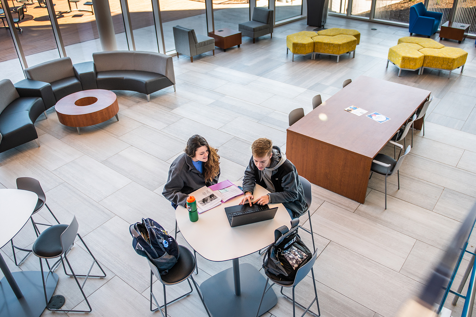 Two students siting at a table looking at a laptop in the new human sciences building.