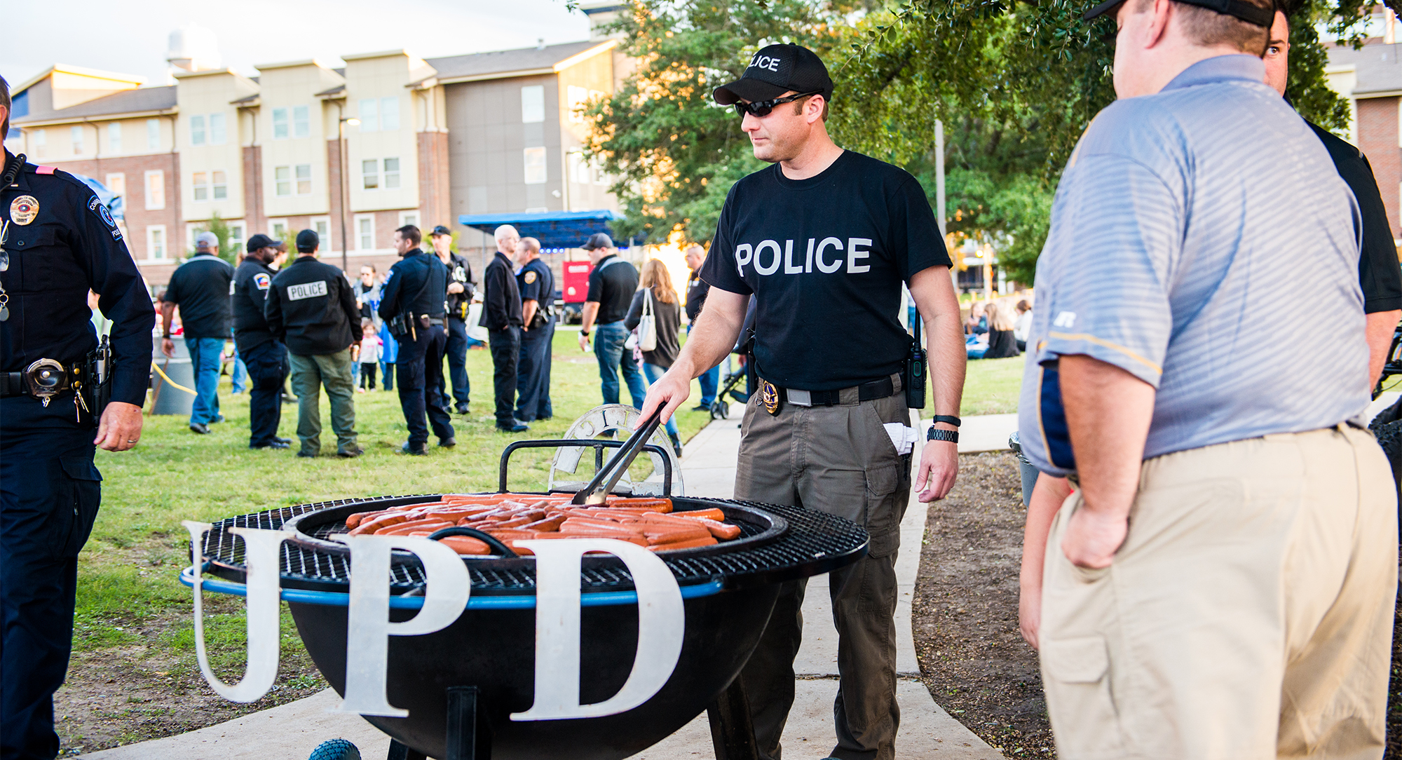 警察在社区活动中烤热狗.