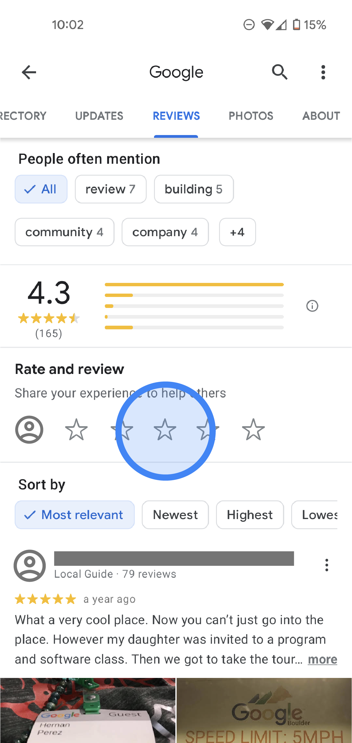 In the Google Maps app, the Reviews tab of a Google office location is shown. At the top, there are tabs labeled Directory, Reviews, Photos, and About. Below, there are review details such as average rating, rating distribution, and a list of all reviews. In the middle of the screen, there is a "Rate & Review" section that shows 5 empty stars. 