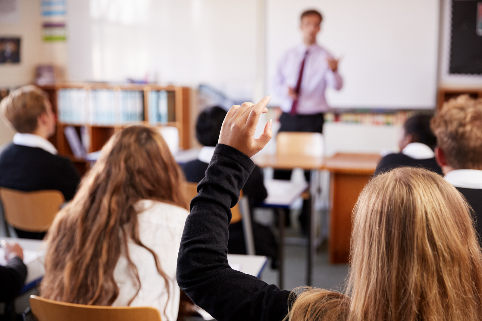 student raising her hand in class