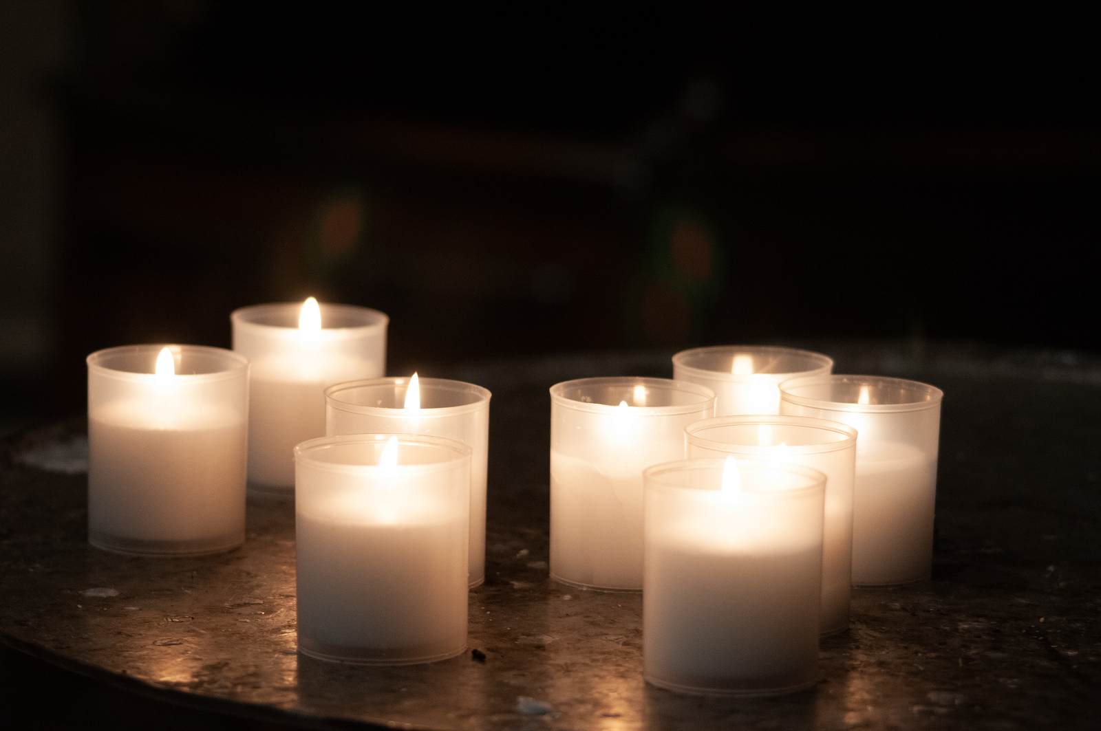 several lit candles in a dark room