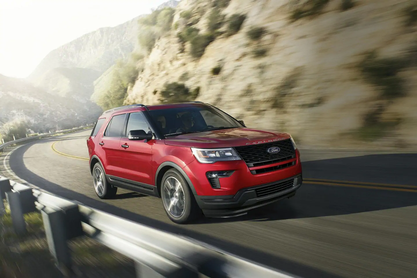 red 2019 ford explorer driving through mountains