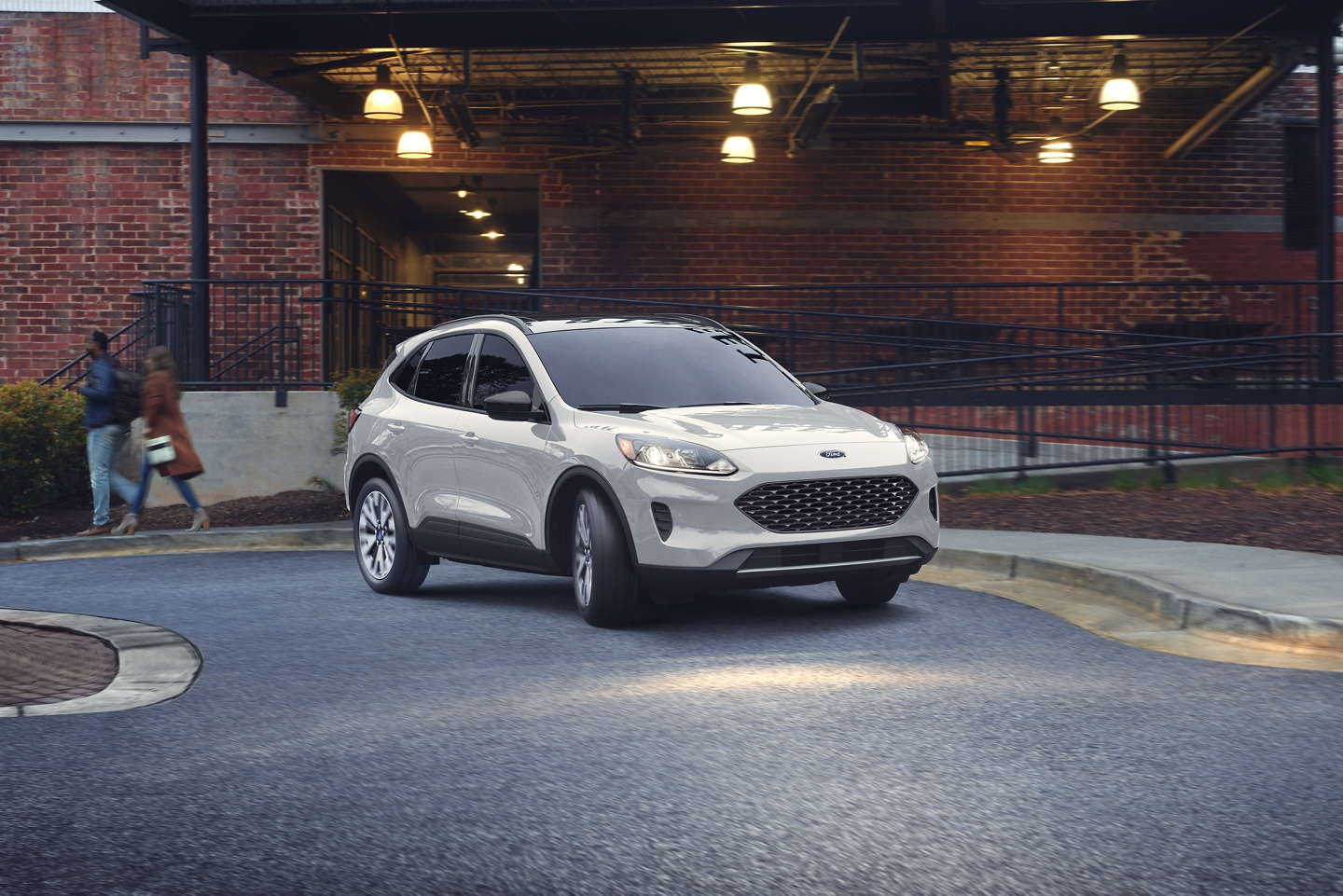 white 2020 ford escape driving past brick building