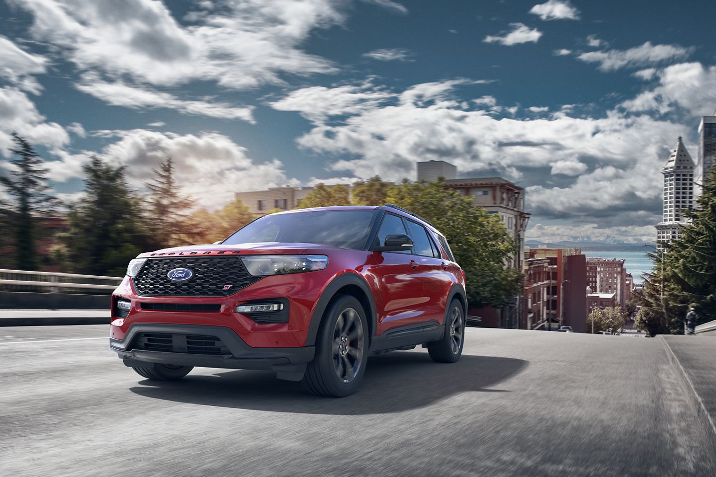 lucid red 2020 ford explorer st driving up a hill