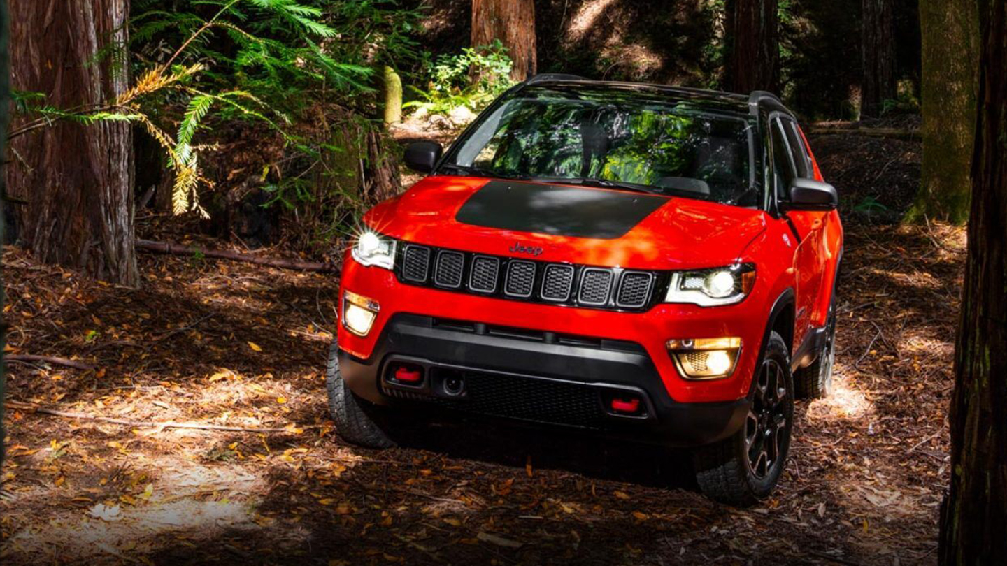 bright red 2019 jeep compass parked in the woods
