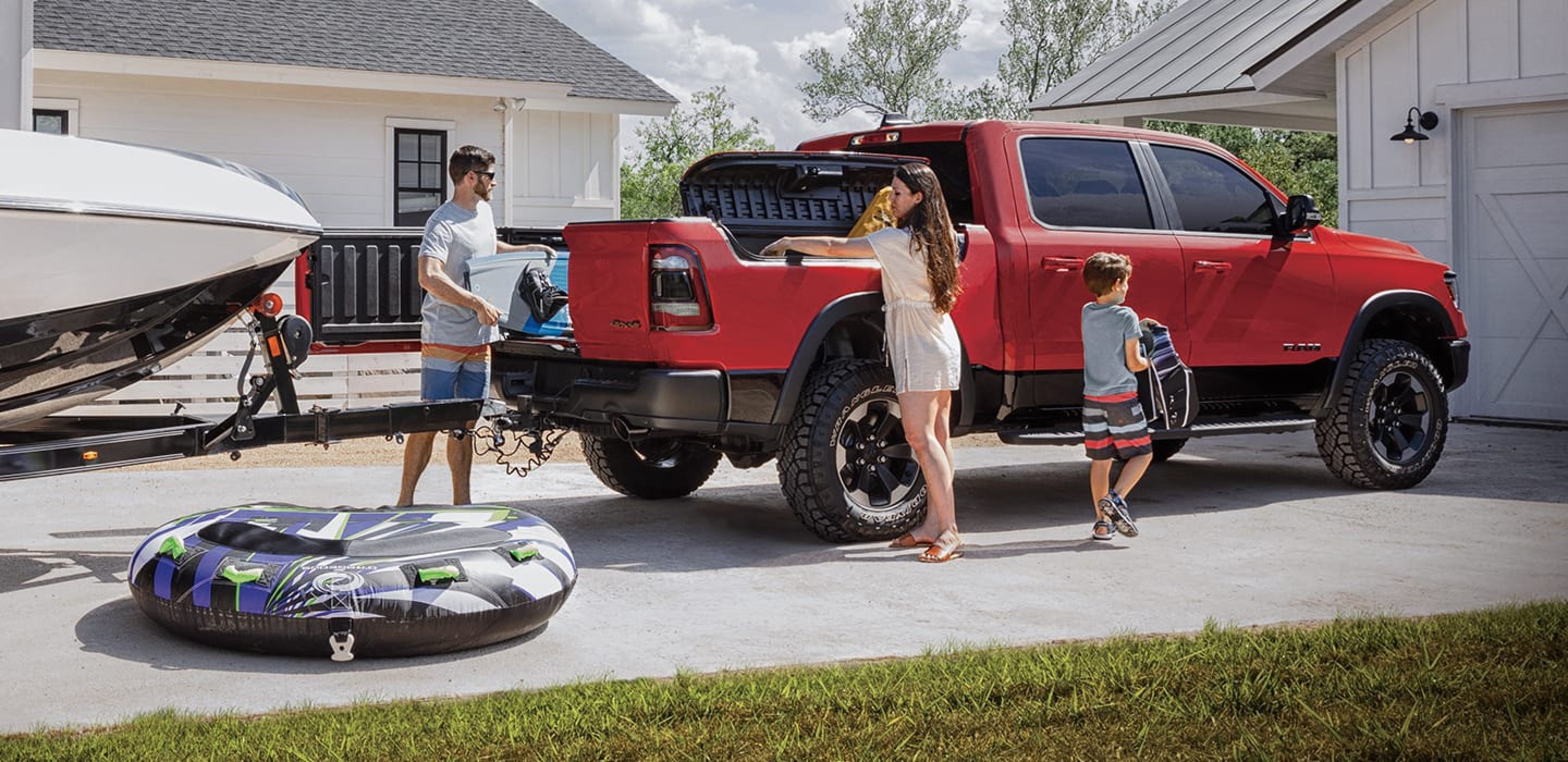 family loading up a red 2020 ram 1500 with gear for a day out on the lake