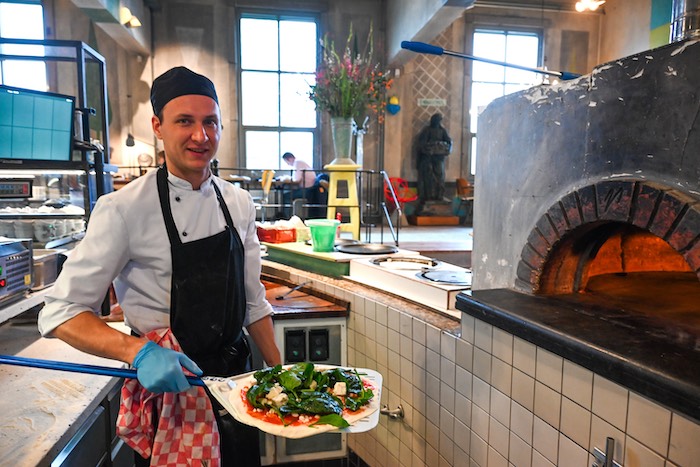 Kok Gabriel bereidt de houtovenpizza met winterspinazie.