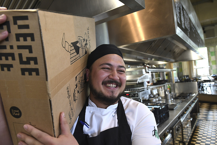 Sous-chef Tim met een levering Friethoes-friet. Tekenaar Joost Swarte ontwierp de huisstijl van de Haarlemse frietbakker
