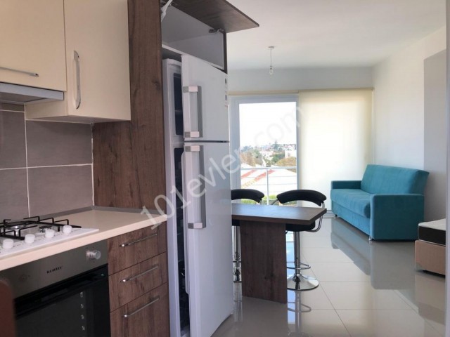 Komplett möbliertes Studio-Apartment zum Verkauf in Alsancak, nur wenige Gehminuten von der Hauptstraße entfernt, mit Gemeinschaftspool und Dachterrasse mit Meerblick.