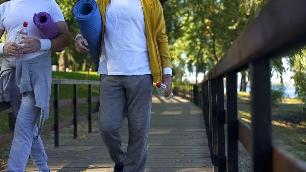 a couple of people walking on a bridge after an outdoor yoga session