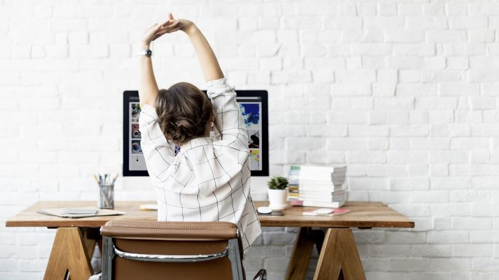 woman stretching at her desk