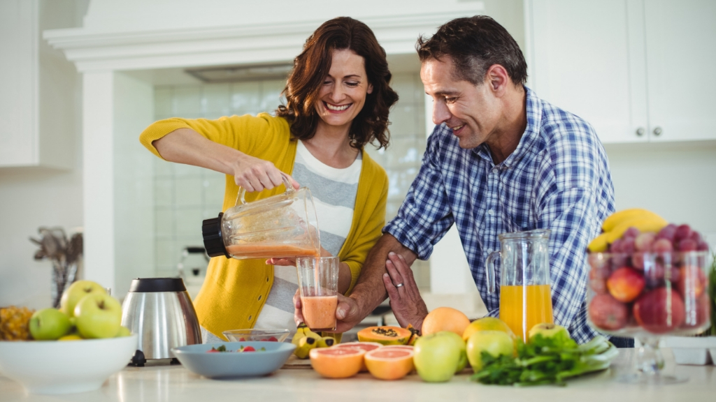 a man and a woman making juice