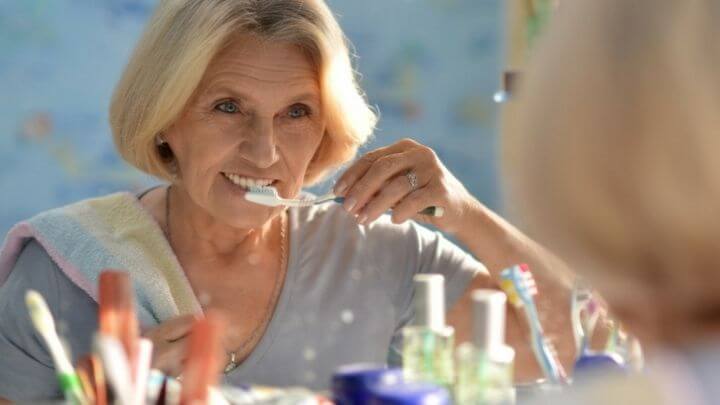 Older woman brushing her teeth