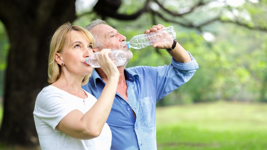 a couple drinking water outside