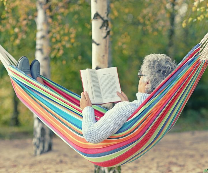 Senior woman reading a book on a hamac