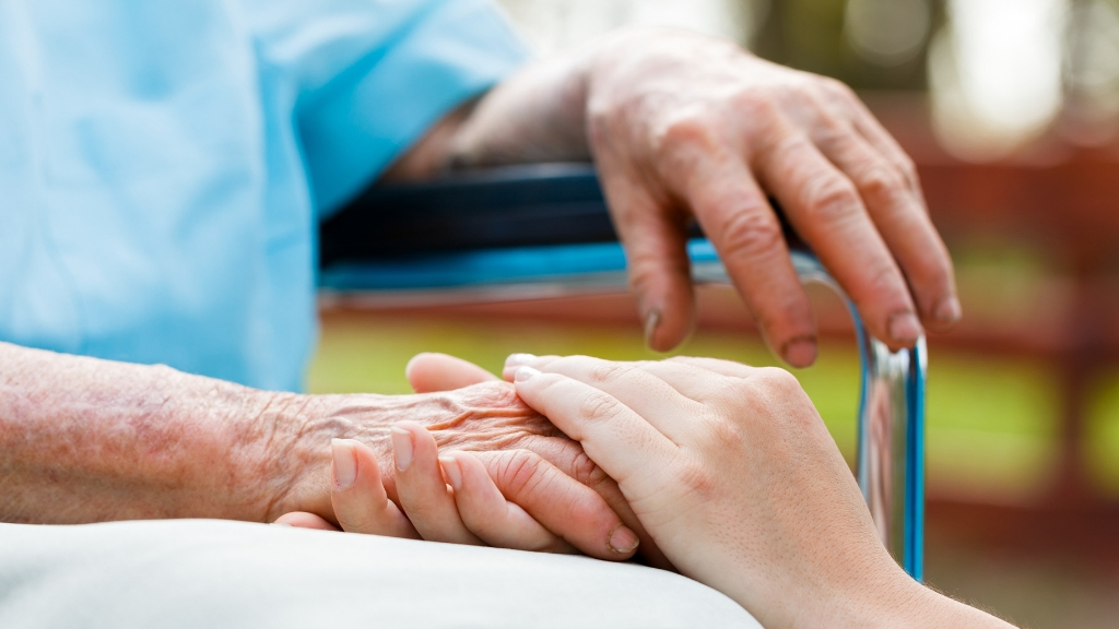 Young hands holding an elderly hand