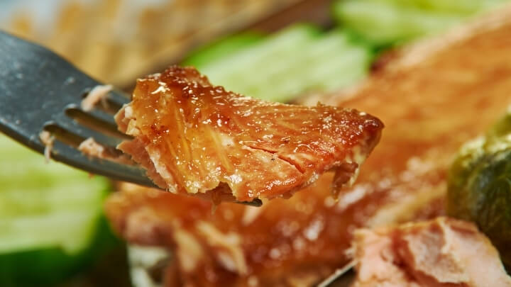 Close up of a piece of glazed salmon on a fork