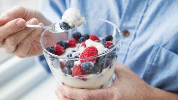 Man eating yogurt with fruits