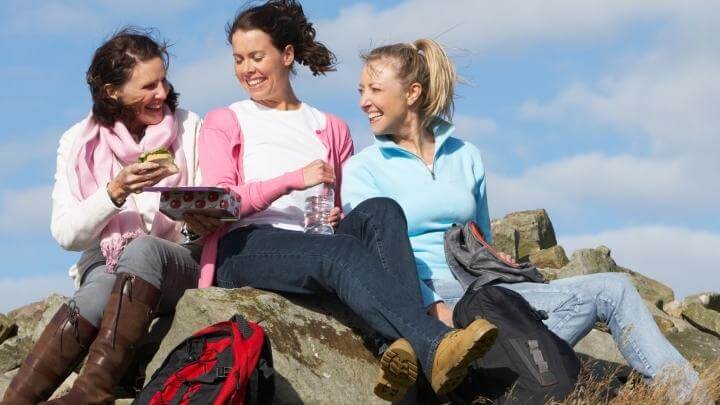 Healthy middle-aged women having a snack after a hike