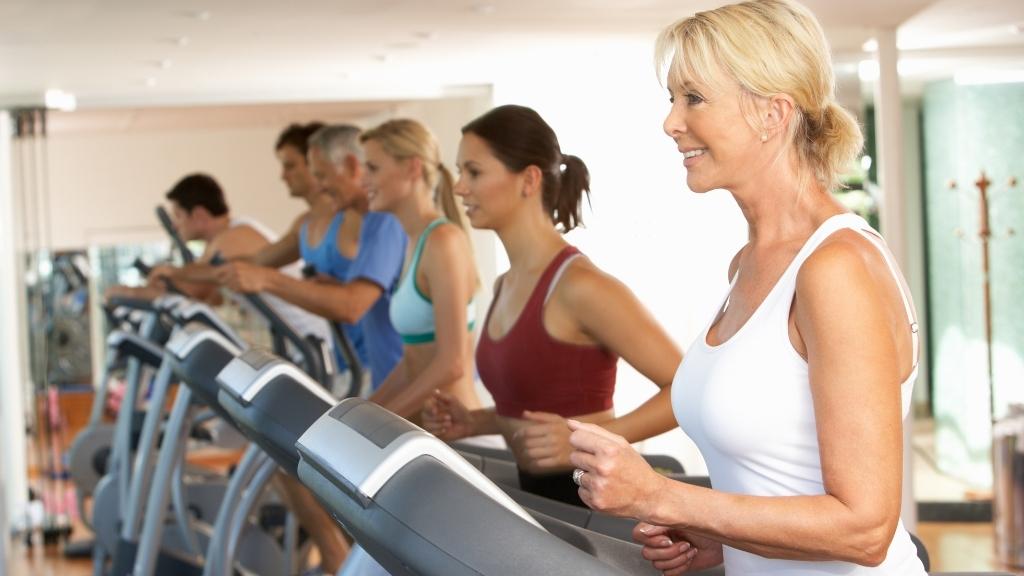 Mature woman working out in a busy gym