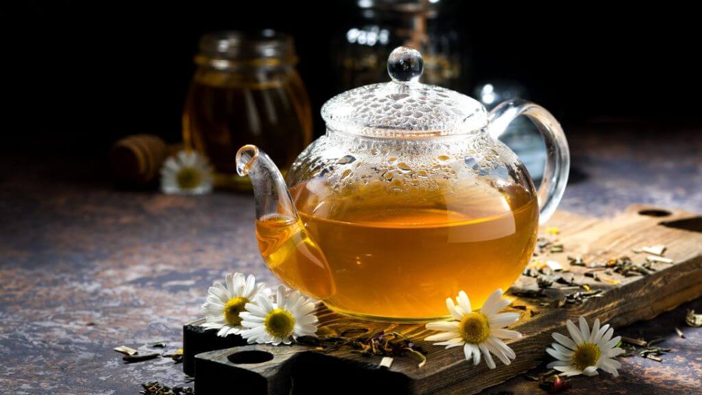 a glass teapot with chamomile tea