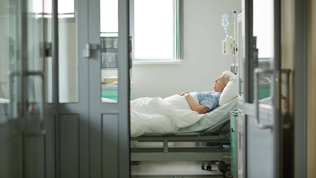 A lonely older woman in a hospital bed