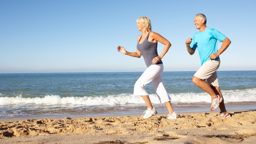 a man and a woman running on a beach