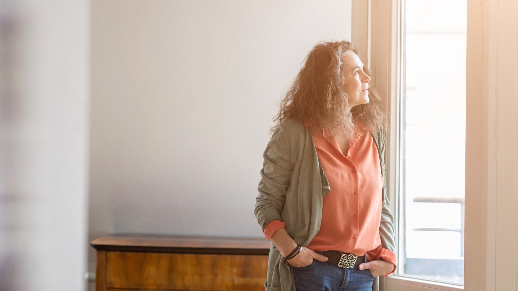 a woman leaning against a window