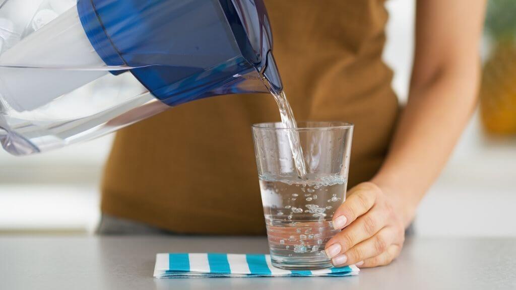 Woman pouring water to a glass