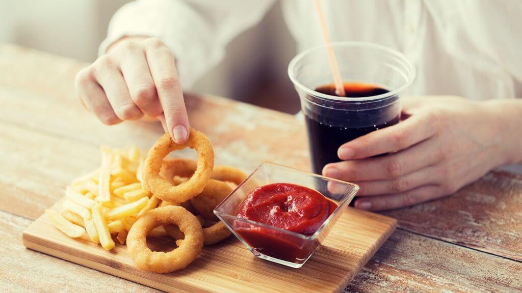 Woman fried fast food and having a diet soda