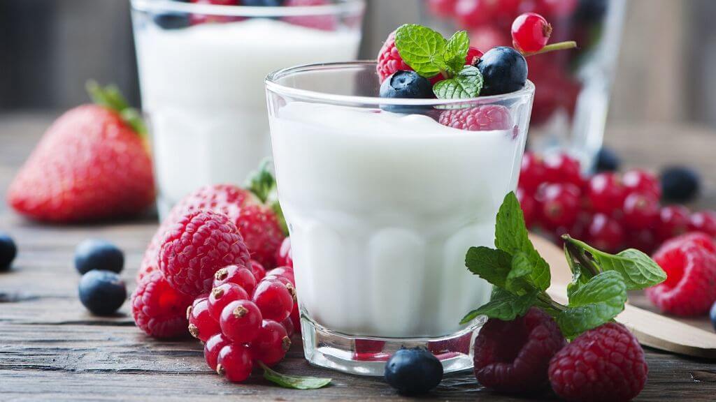 a glass of milk with berries