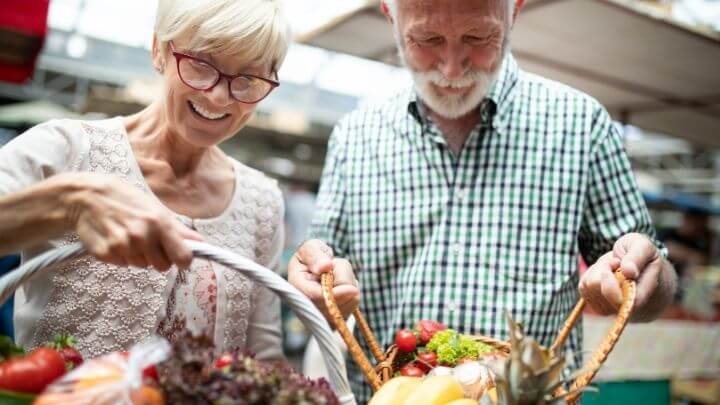 a man and woman holding a basket of food