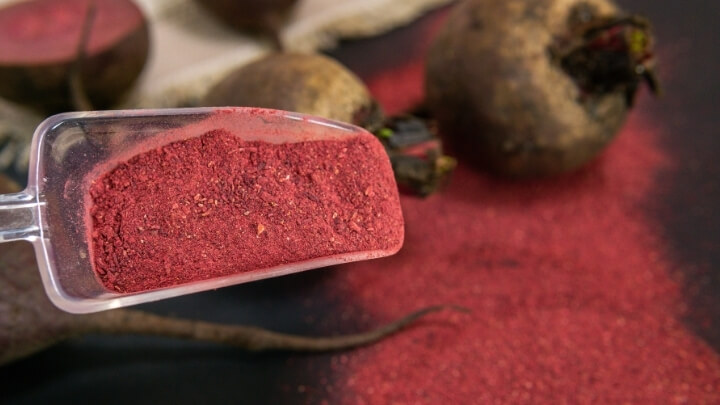 Beetroot powder in a clear plastic spoon