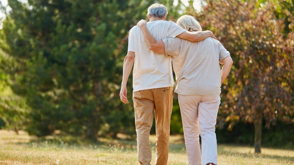 Elderly couple walking in each other's arms