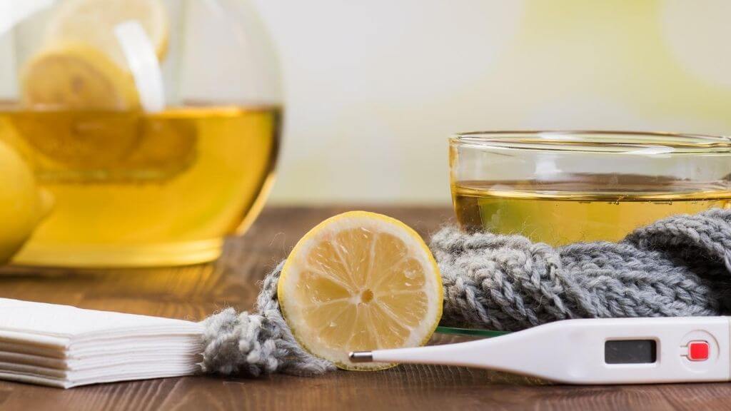 a glass of liquid next to a cell phone and a lemon