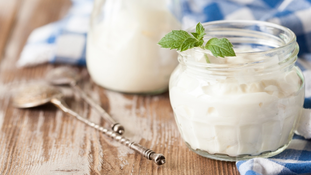 a glass of milk with a leaf on top