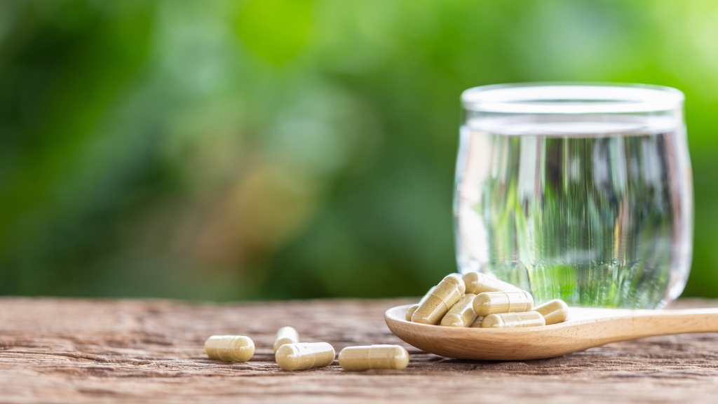 a glass of milk next to a pile of pills