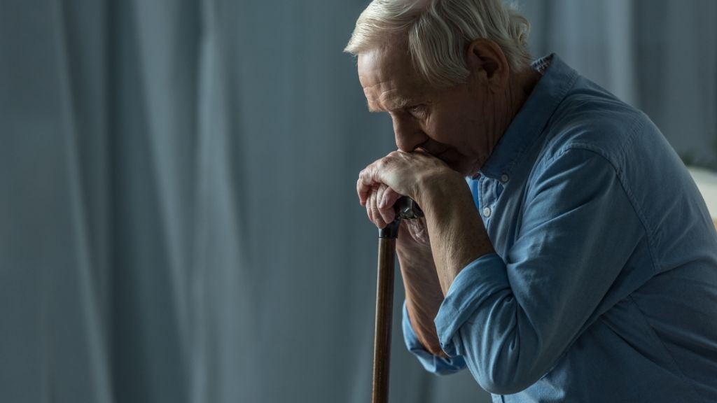 Older man sitting down lost in his thoughts