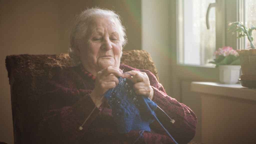 Happy older woman knitting